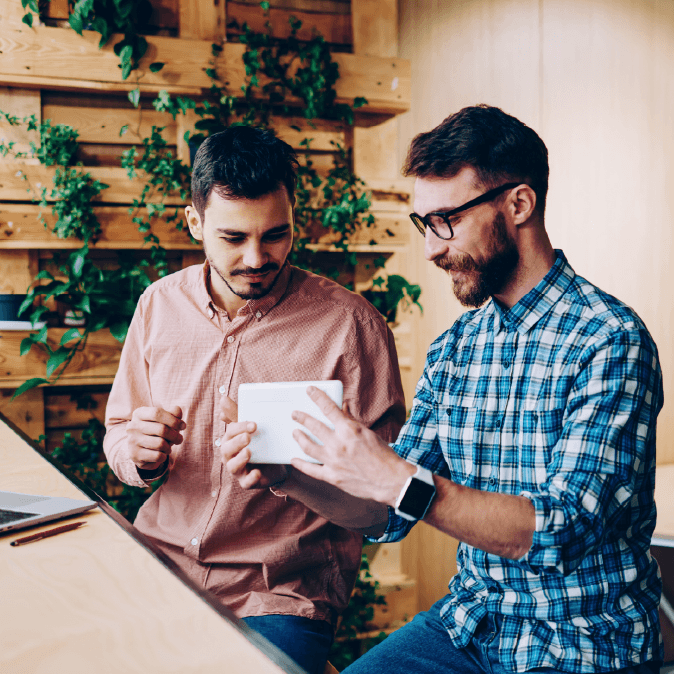 two men chatting sitting at a desk